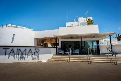 a white building with stairs and chairs on it at Hotel Taimar in Costa Calma