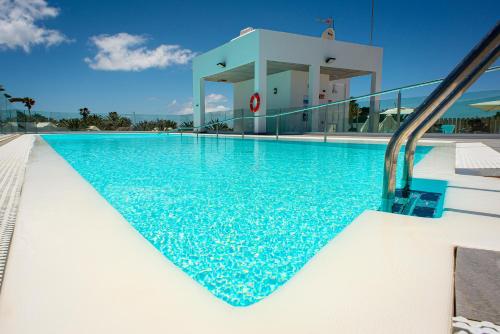 a swimming pool with a slide in front of a building at Hotel Taimar in Costa Calma