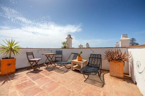 a patio with chairs and a table on a roof at La Casa de la Favorita in Tarifa