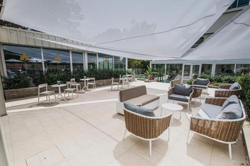 a patio with chairs and tables in a building at Principe Alogna Hotel & SPA in Altavilla Milicia