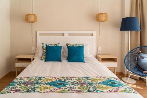a bedroom with a large bed with blue pillows at Hotel Aubí in Sant Antoni de Calonge