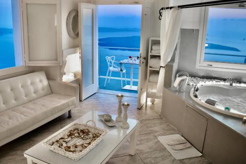 ein Wohnzimmer mit einem weißen Sofa und einer Badewanne in der Unterkunft Aeolos Art & Eco Suites Adults Only in Imerovigli