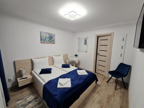 a bedroom with a bed and a blue chair at Splendid House in Făgăraş