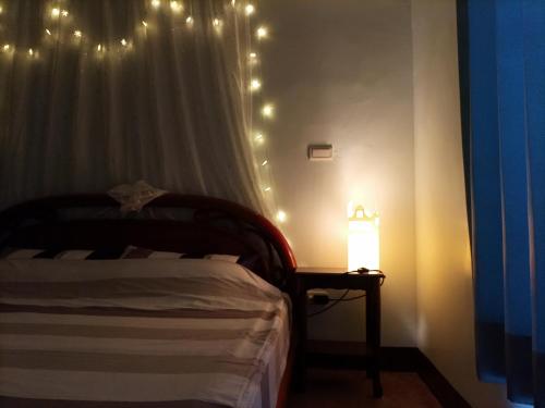 a bedroom with a bed and a lamp with lights at Smile house Homestay in Taiping