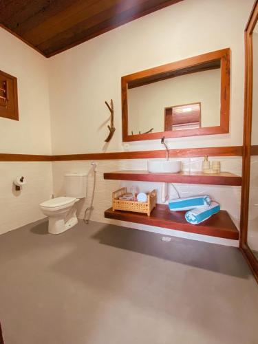 a bathroom with a sink and a toilet and a mirror at UMAMI RESIDENCE in Icaraí