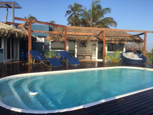 una piscina frente a una casa en Cabana Chic Sunrise, en Tatajuba
