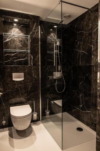 a bathroom with a toilet and a glass shower at Casino 2000 - Adult Guests Only in Mondorf-les-Bains