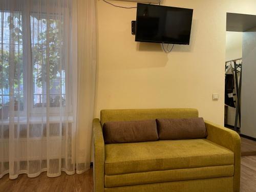 ein Wohnzimmer mit einem Sofa und einem Flachbild-TV in der Unterkunft АpartmentAnna in Odessa