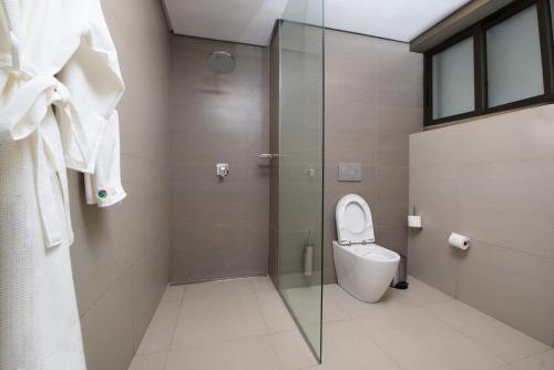 a bathroom with a toilet and a glass shower at Sunbird Waterfront in Salima