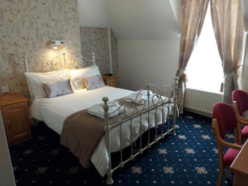 een slaapkamer met een bed en een raam bij The Beaumont in Sittingbourne