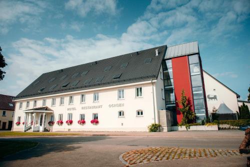 duży biały budynek z czarnym dachem w obiekcie Hotel Ochsen & Restaurant w mieście Merklingen