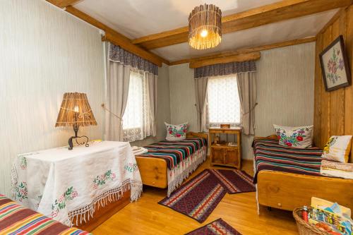 a living room with two beds and a table at Agrousadba UTSISHY - U hutarskoj tsishy, Volkovysk in Vawkavysk