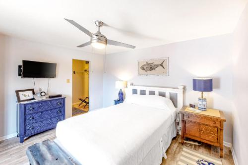 a bedroom with a white bed and a tv at Sandy Bottom KH107 in Kitty Hawk