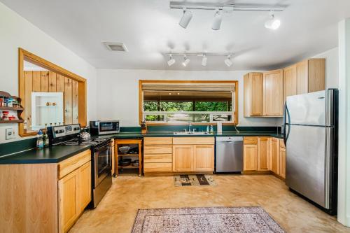 a kitchen with wooden cabinets and a stainless steel refrigerator at Country Escape in Clinton
