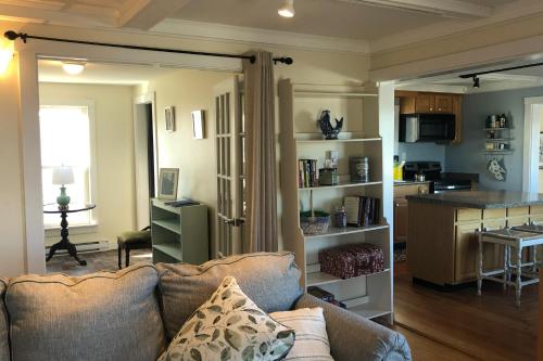 a living room with a couch and a kitchen at Windows on the Sea in Rockland