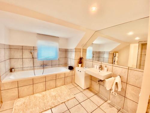 y baño con bañera y lavamanos. en Mariazeller Resort Landliebe, en Mariazell
