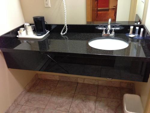 a bathroom with a black counter with a sink at Canadas Best Value Inn & Suites-Vernon in Vernon
