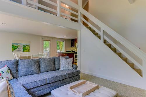 a living room with a blue couch and stairs at Fairy Cottage in the Wood in Bartlett