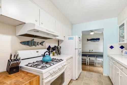 a white kitchen with a stove and a refrigerator at Beach Rendezvous in Seaside