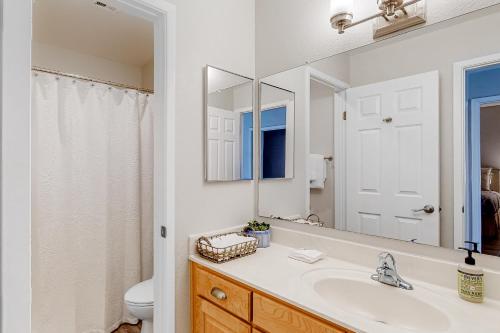 W łazience znajduje się umywalka, toaleta i lustro. w obiekcie Scottsdale Retreat w mieście Scottsdale