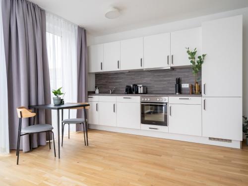 a kitchen with white cabinets and a table at Limehome Dresden Wallstraße - Digital Access in Dresden