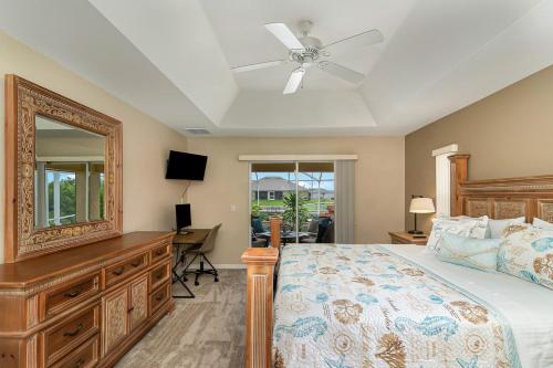 Schlafzimmer mit einem Bett, einer Kommode und einem Spiegel in der Unterkunft Paradise Palms in Cape Coral
