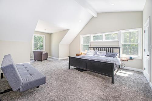 a bedroom with a bed and a chair and windows at Friendly Farms in Lakeside
