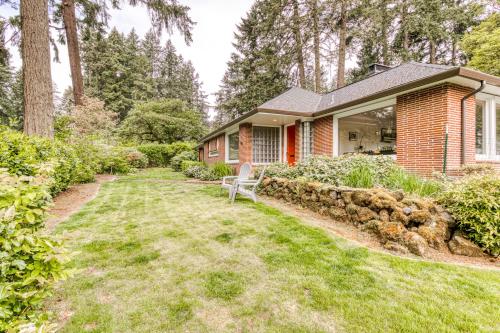 a brick house with a bench in the yard at Lake Oswego Mid-Century in Lake Oswego