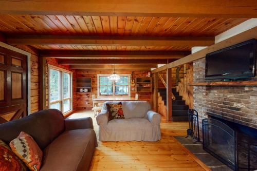a living room with a couch and a fireplace at Cabin on the Ridge in Tinkerville