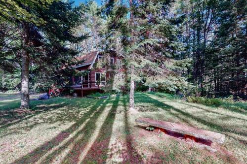 a house in the middle of a field with a bench at Cabin on the Ridge in Tinkerville