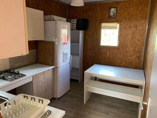 une cuisine avec un réfrigérateur blanc et une fenêtre dans l'établissement La case bignone, à Saint-André