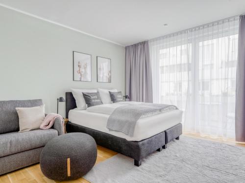 a bedroom with a king sized bed and a couch at Limehome Dresden Wallstraße - Digital Access in Dresden