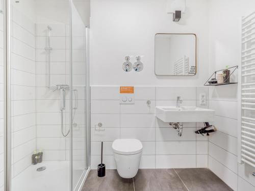 a bathroom with a toilet and a sink and a shower at Limehome Dresden Wallstraße - Digital Access in Dresden
