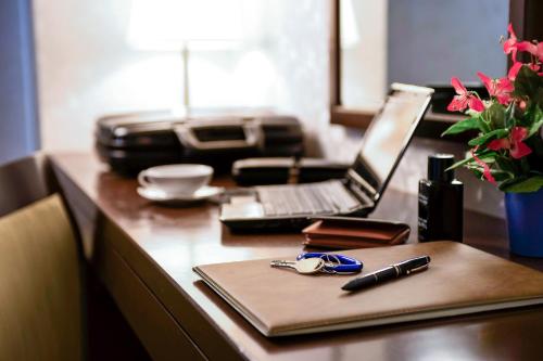 a desk with a laptop computer and a pen on it at Plaza Hotel Winterthur in Winterthur
