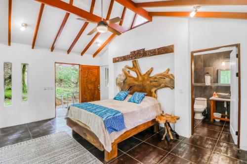 1 dormitorio con 1 cama con cabecero de madera en Lost Pools Bungalow, en Uvita