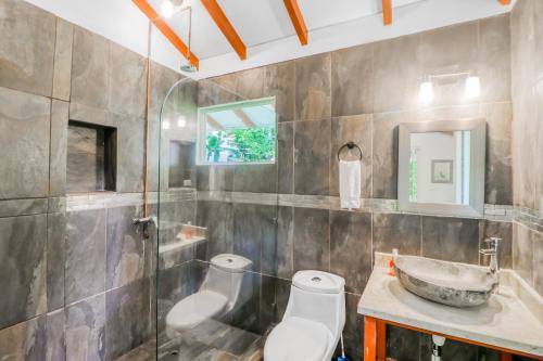 La salle de bains est pourvue d'un lavabo et de toilettes. dans l'établissement Lost Pools Bungalow, à Uvita
