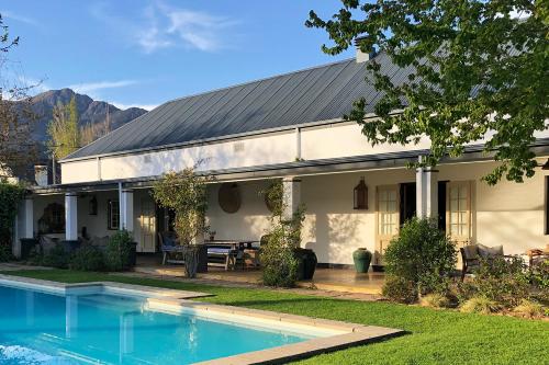 a house with a swimming pool in front of it at La Clé Village in Franschhoek