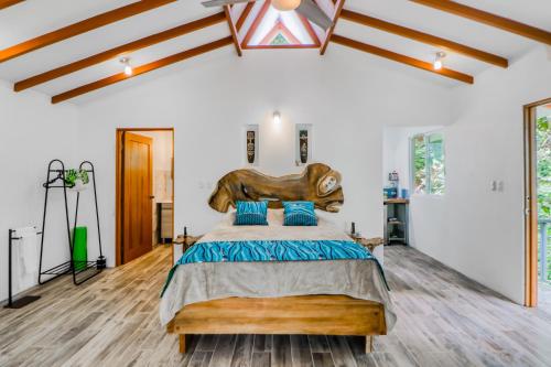a bedroom with a large bed with a wooden headboard at Lost Pools Bungalow in Uvita