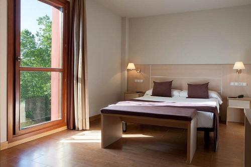 a bedroom with a bed and a large window at Hotel Balneario Areatza Nº 01224 in Areatza