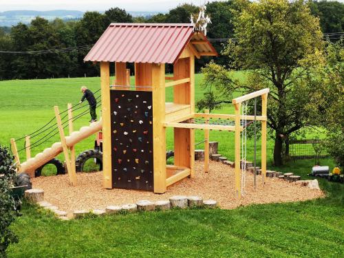 a man on a playground with a play structure at Haslacher Hof in Waging am See
