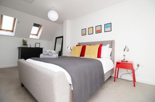 een slaapkamer met een groot bed en een rode tafel bij No2 Marina Walk by Stay South Wales -FREE Parking in Landore