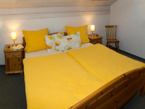 ein Schlafzimmer mit einem großen Bett mit gelber Bettwäsche in der Unterkunft Haslacher Hof in Waging am See