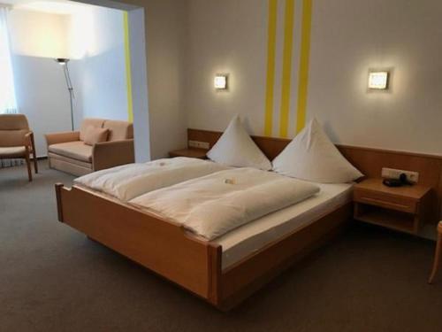 a bedroom with a large bed and a living room at Hotel Garni Schick in Oberursel