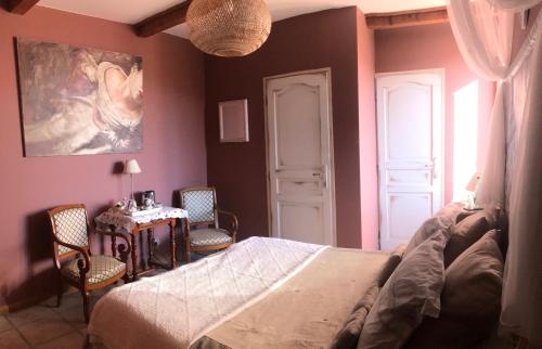 a bedroom with a bed and a table and chairs at Domaine de la Manse in Villeneuve-de-Berg