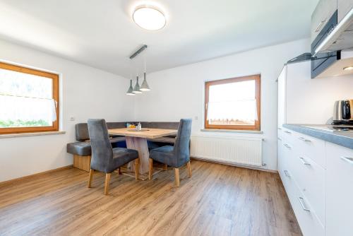 a kitchen and dining room with a table and chairs at AlpenLiving in Mayrhofen