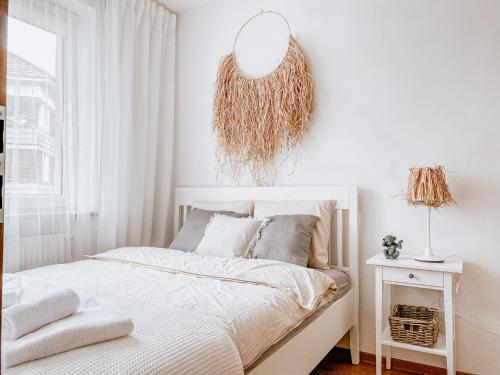 a white bedroom with a bed and a mirror at Apartamenty Flat White Ruczajowa in Zielona Góra