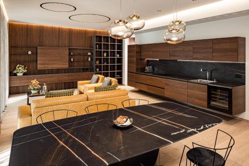 a kitchen and living room with a table and chairs at ARIA Retreat & SPA - The Leading Hotels of the World, located within Parco San Marco Resort in Porlezza
