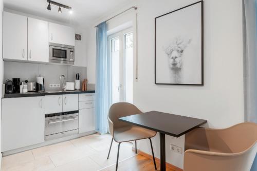 a kitchen with a table and chairs in a room at limehome Ingolstadt Bauhofstraße in Ingolstadt