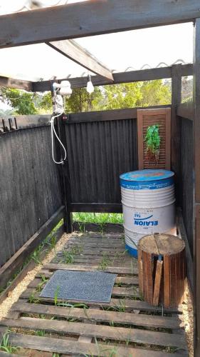 a patio with a barrel and a potted plant at Ecaffe Hotel Pousada Container - Coqueiral MG in Coqueiral
