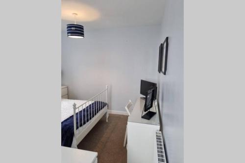 a small bedroom with a bed and a crib at 2 Bedroom Seafront Apartment in Felixstowe